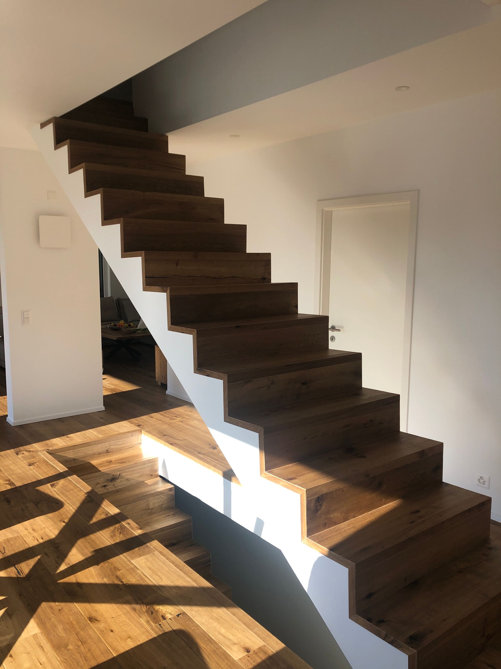 A wooden staircase with a white railing in a room