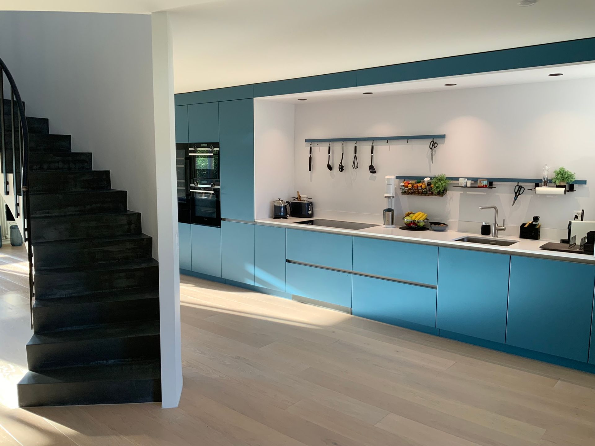 A kitchen with blue cabinets and a spiral staircase