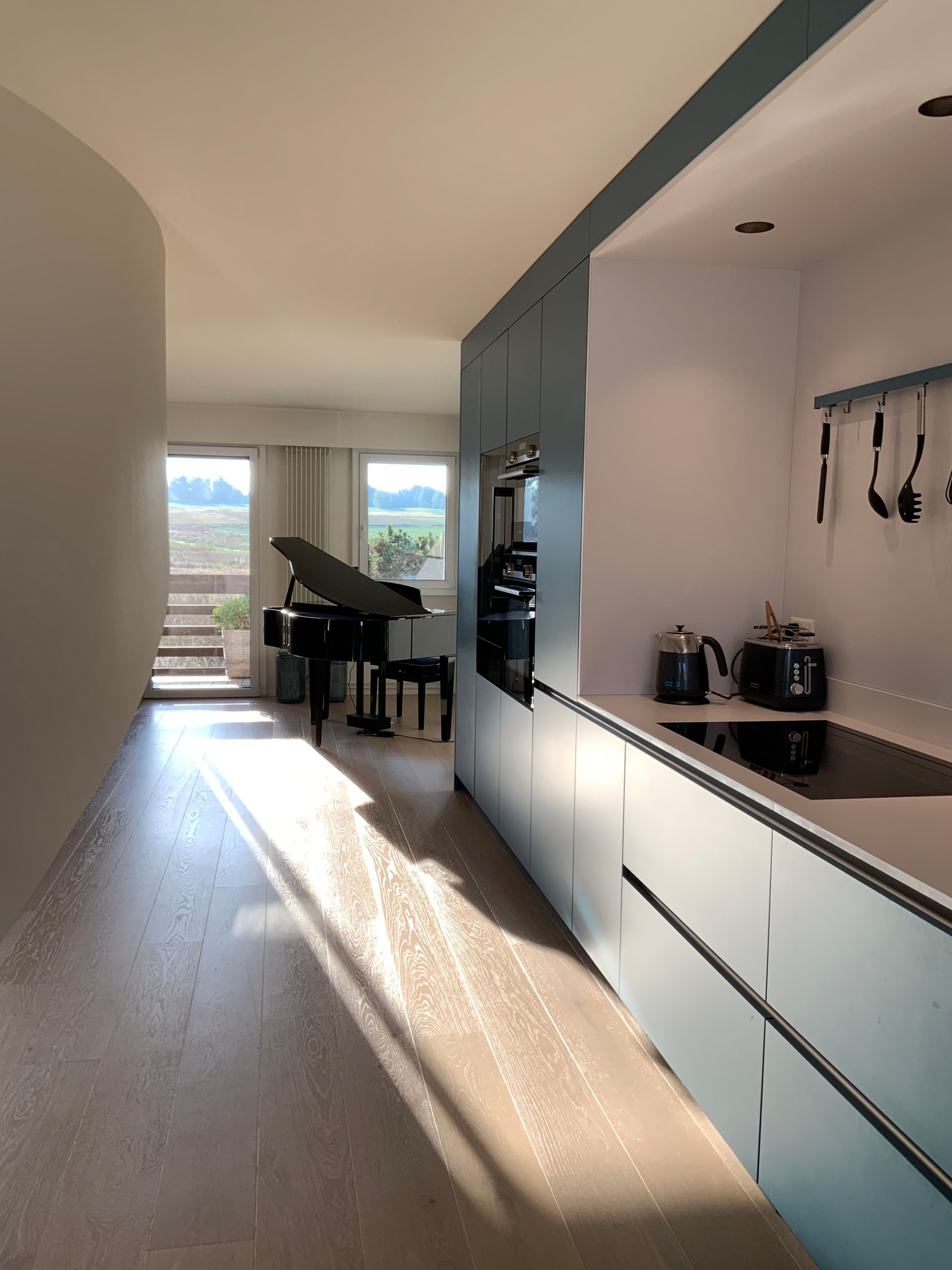 A kitchen with blue cabinets and a piano in the background