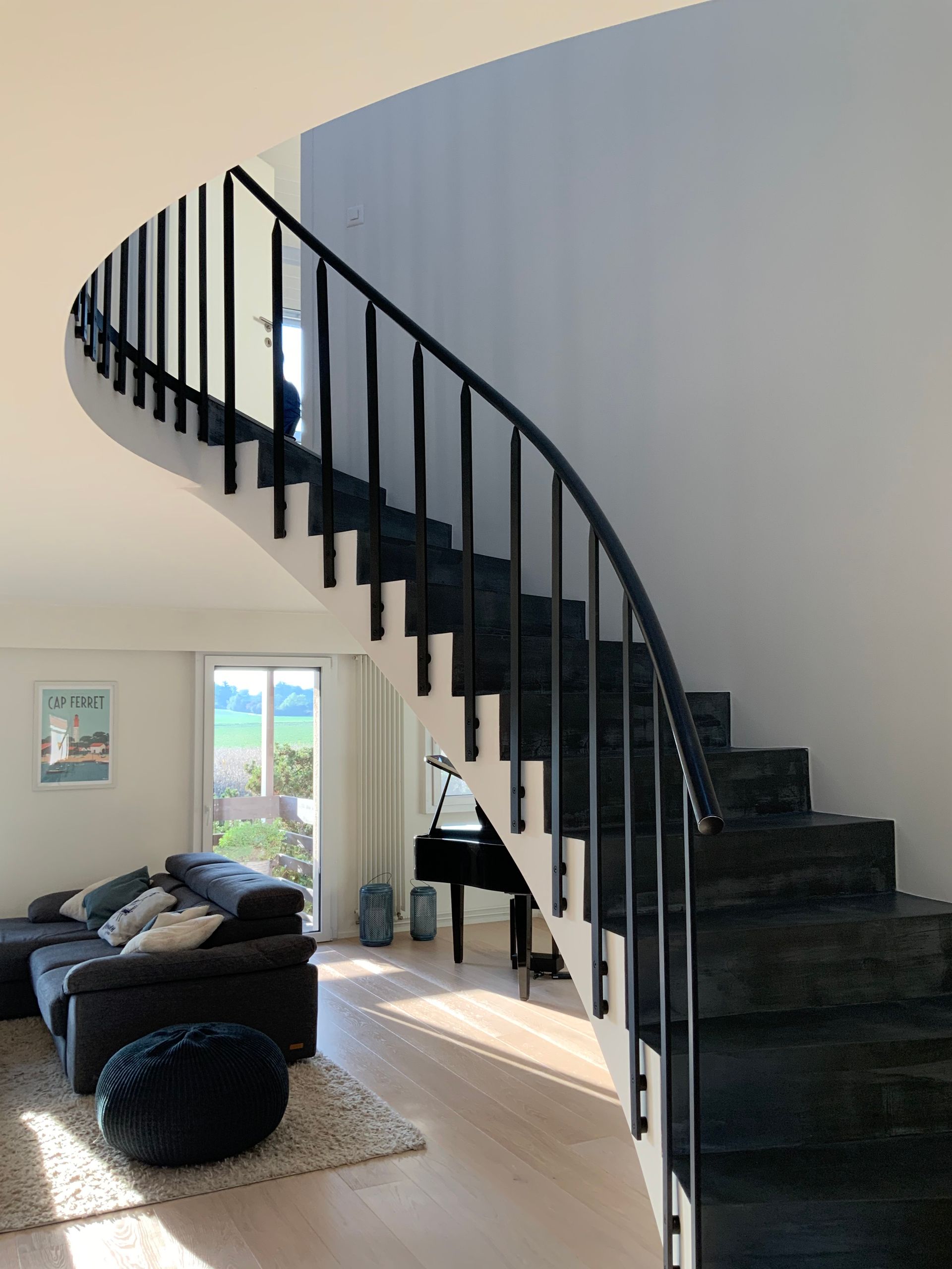 A living room with a spiral staircase and a piano