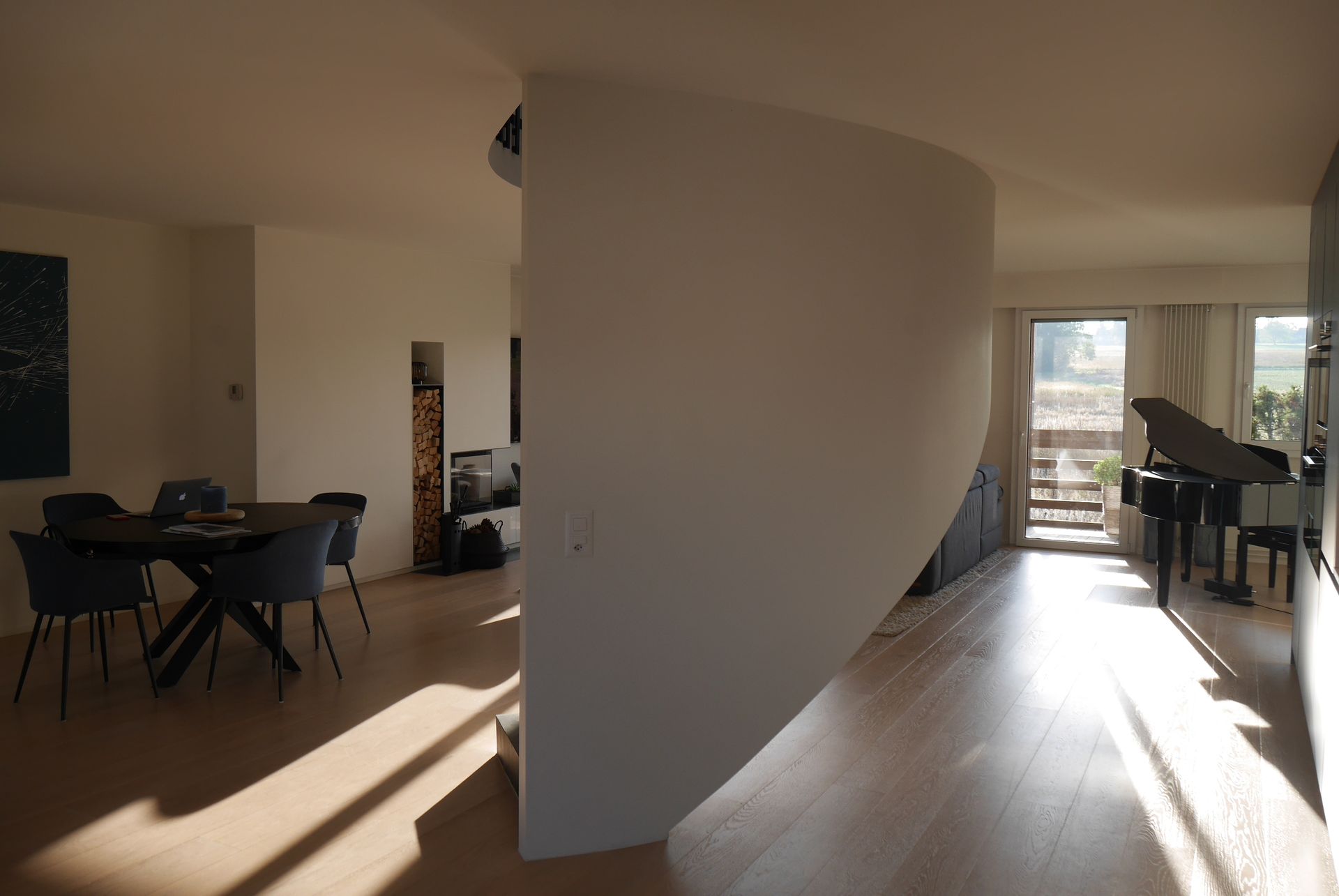 A living room with a table and chairs and a piano
