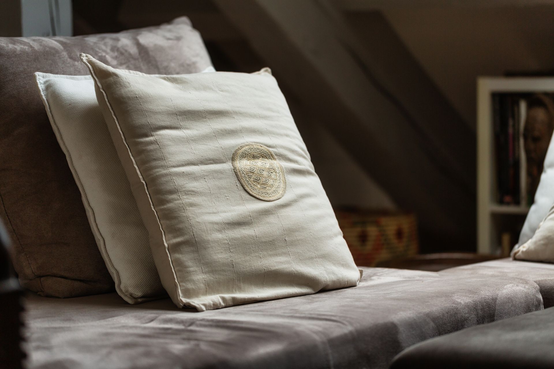 A couch with three pillows on it in a living room.