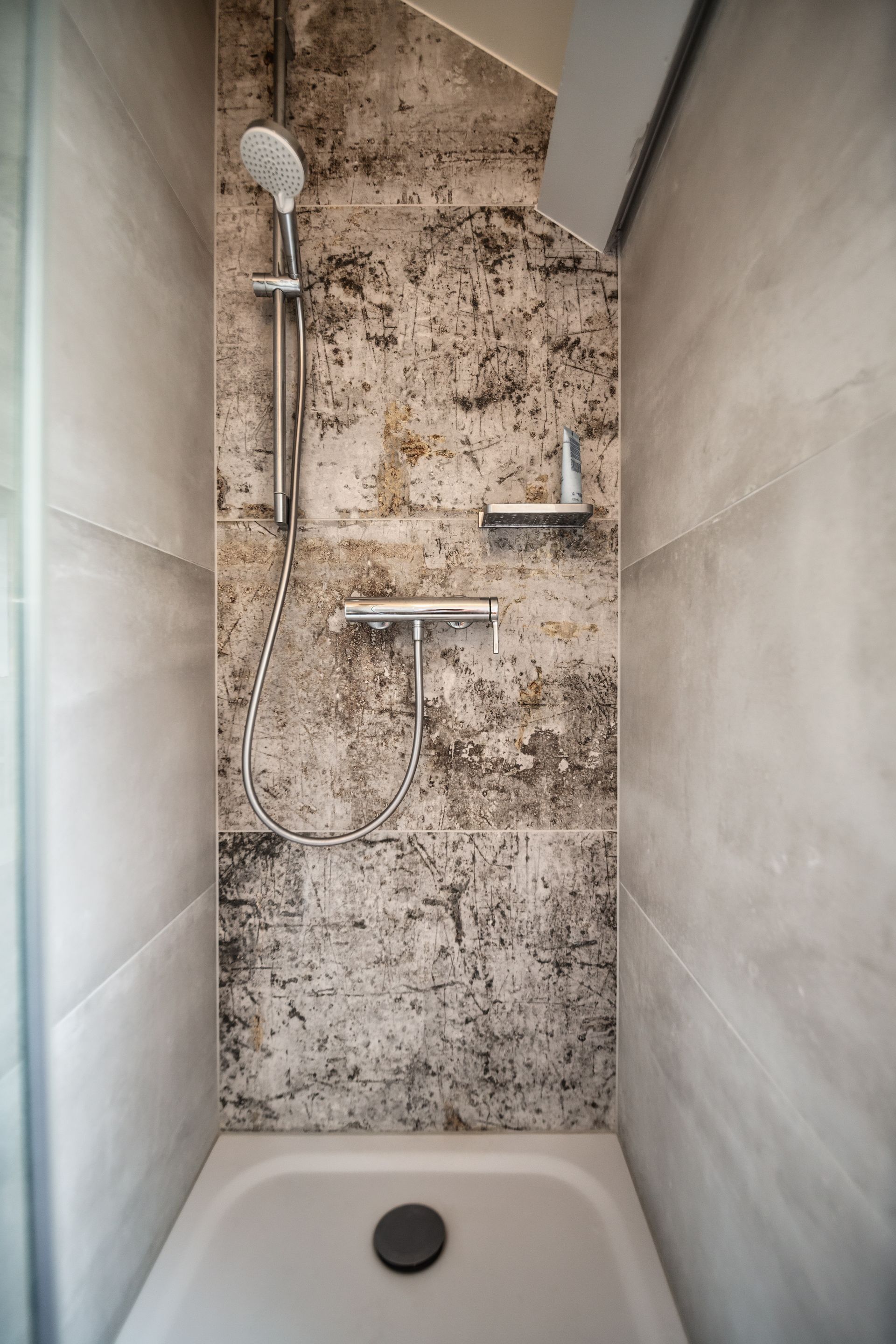 A bathroom with a shower and a shower head.