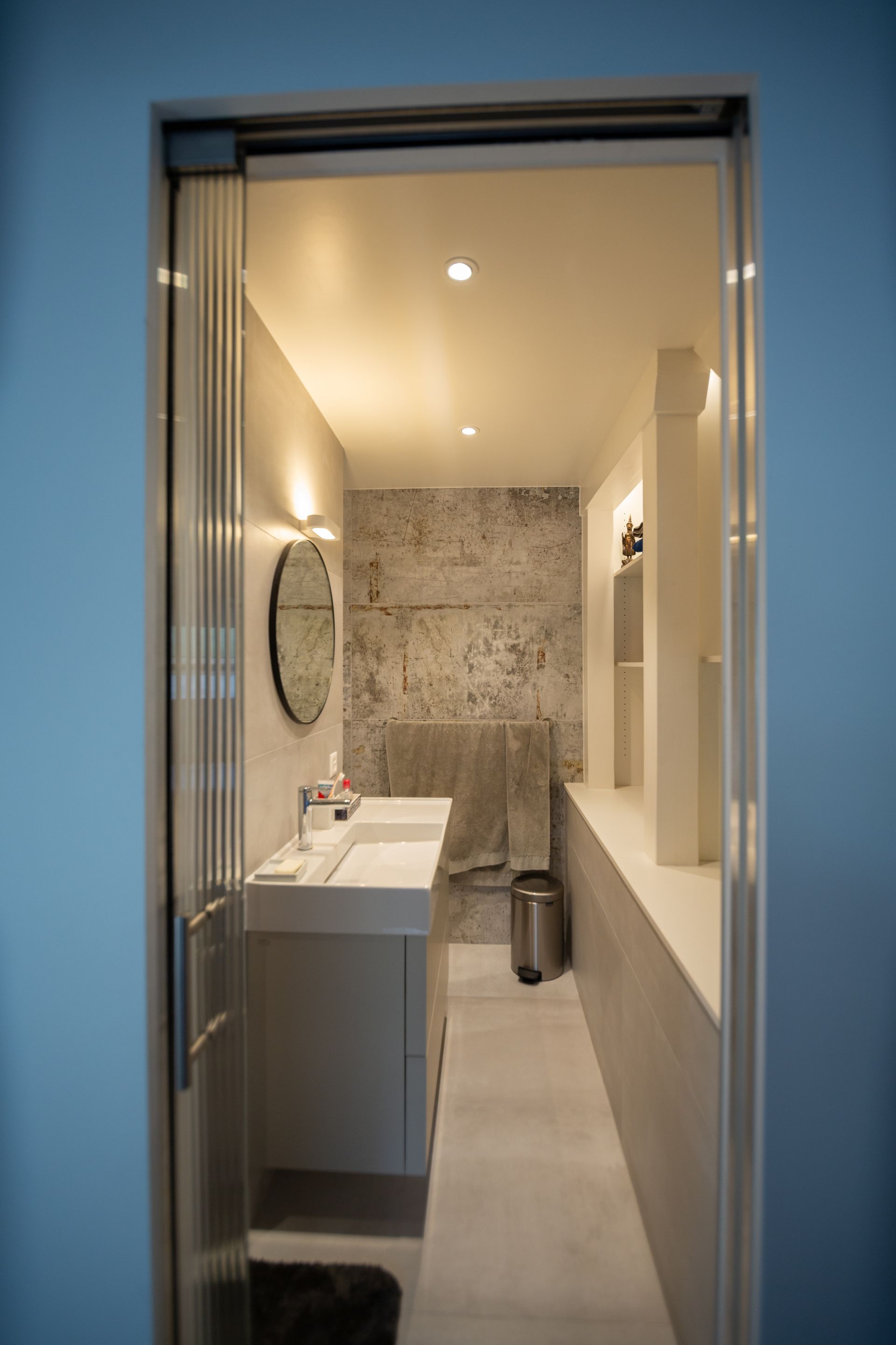 A bathroom with two sinks , a mirror and a trash can.