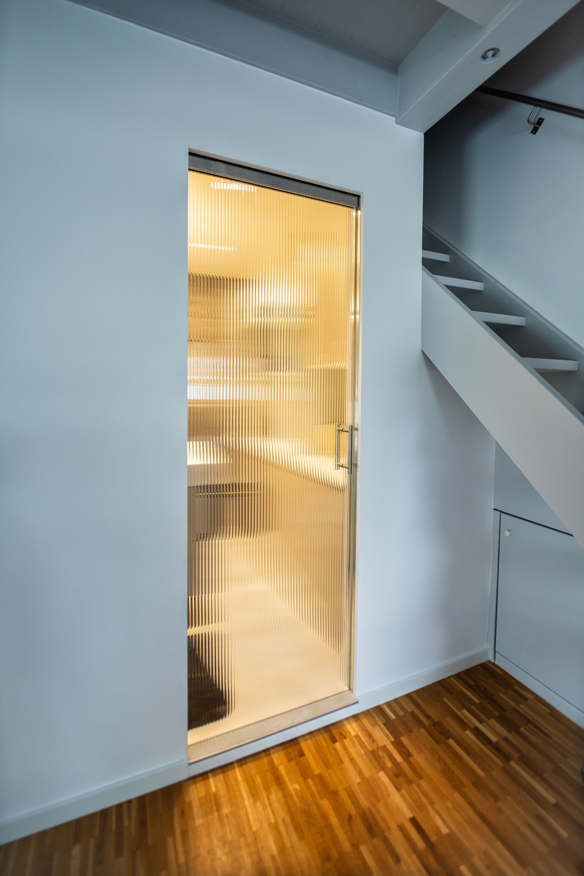 A room with a staircase and a glass door