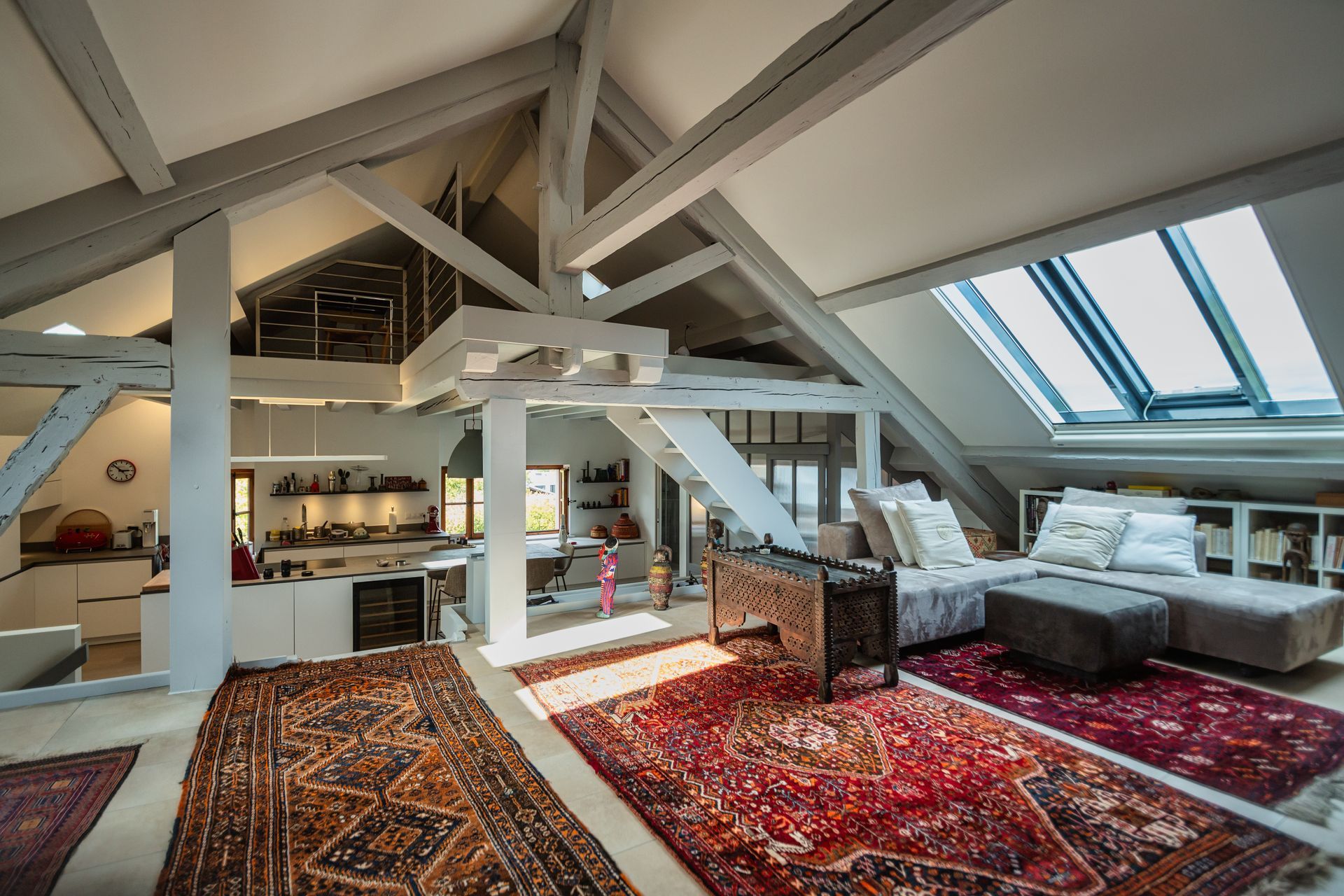 A living room with a rug and a couch in an attic.