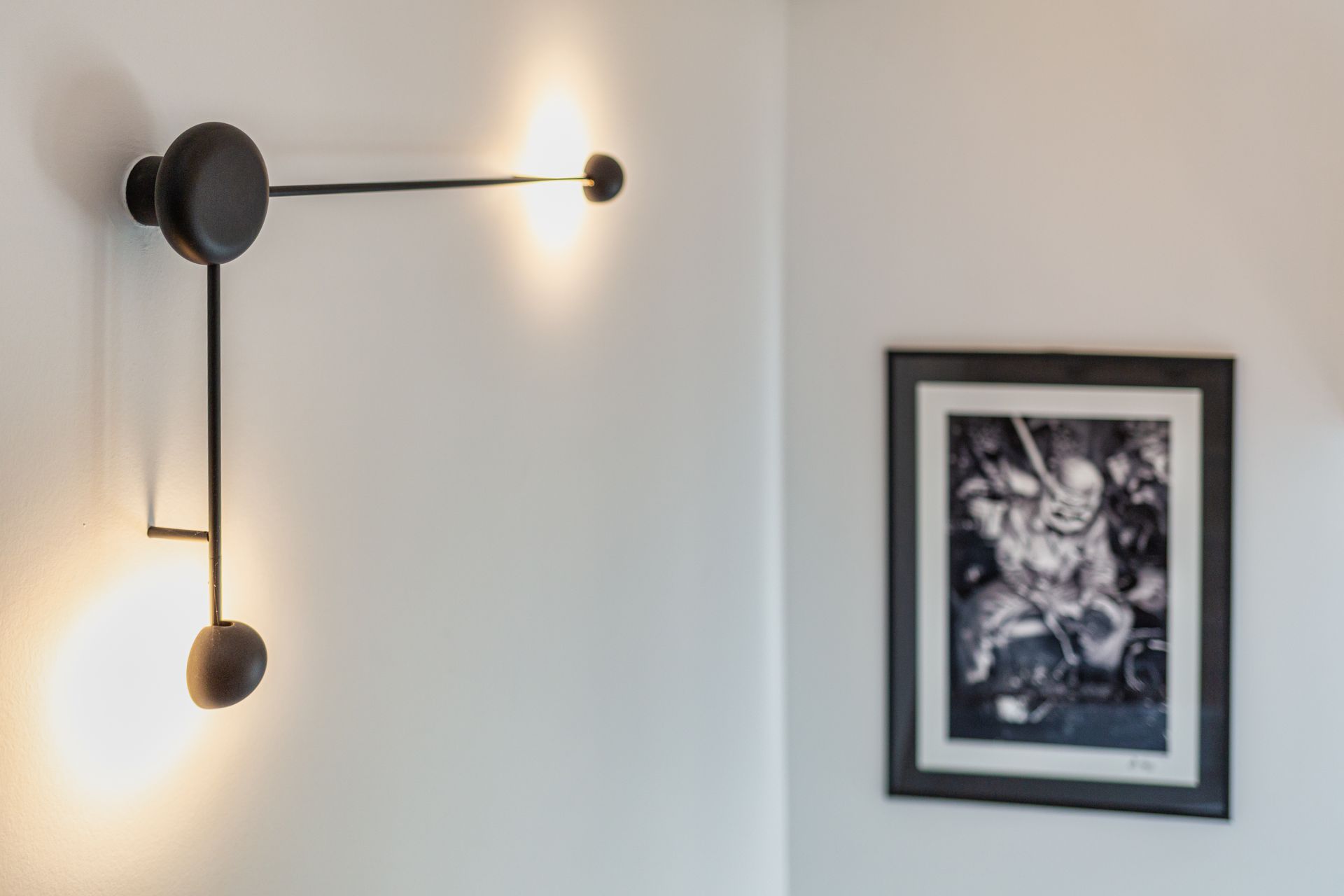 There is a picture on the wall and a light on the wall.