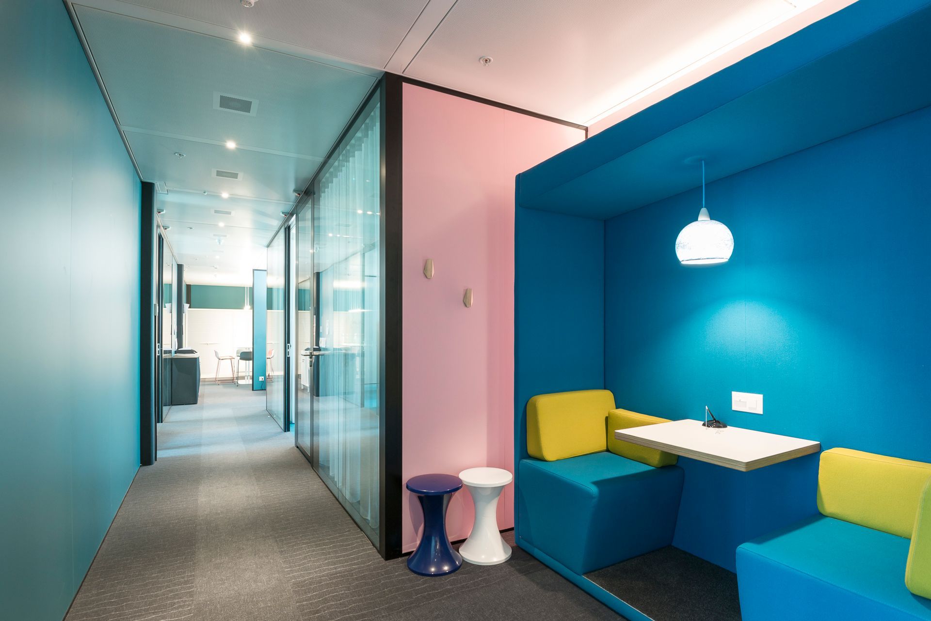 A hallway with a blue wall and a blue couch.