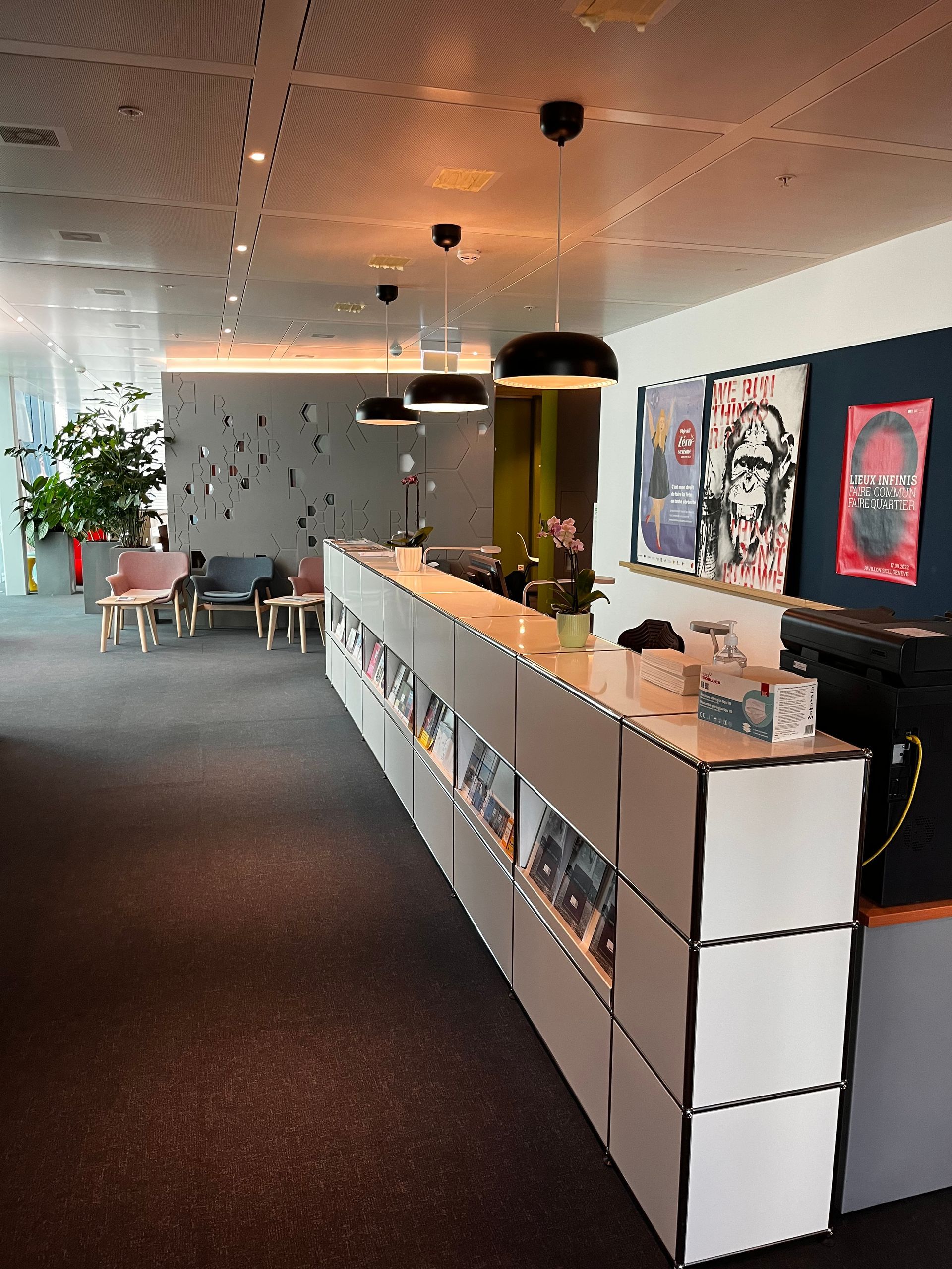 A long white counter in a room with posters on the wall