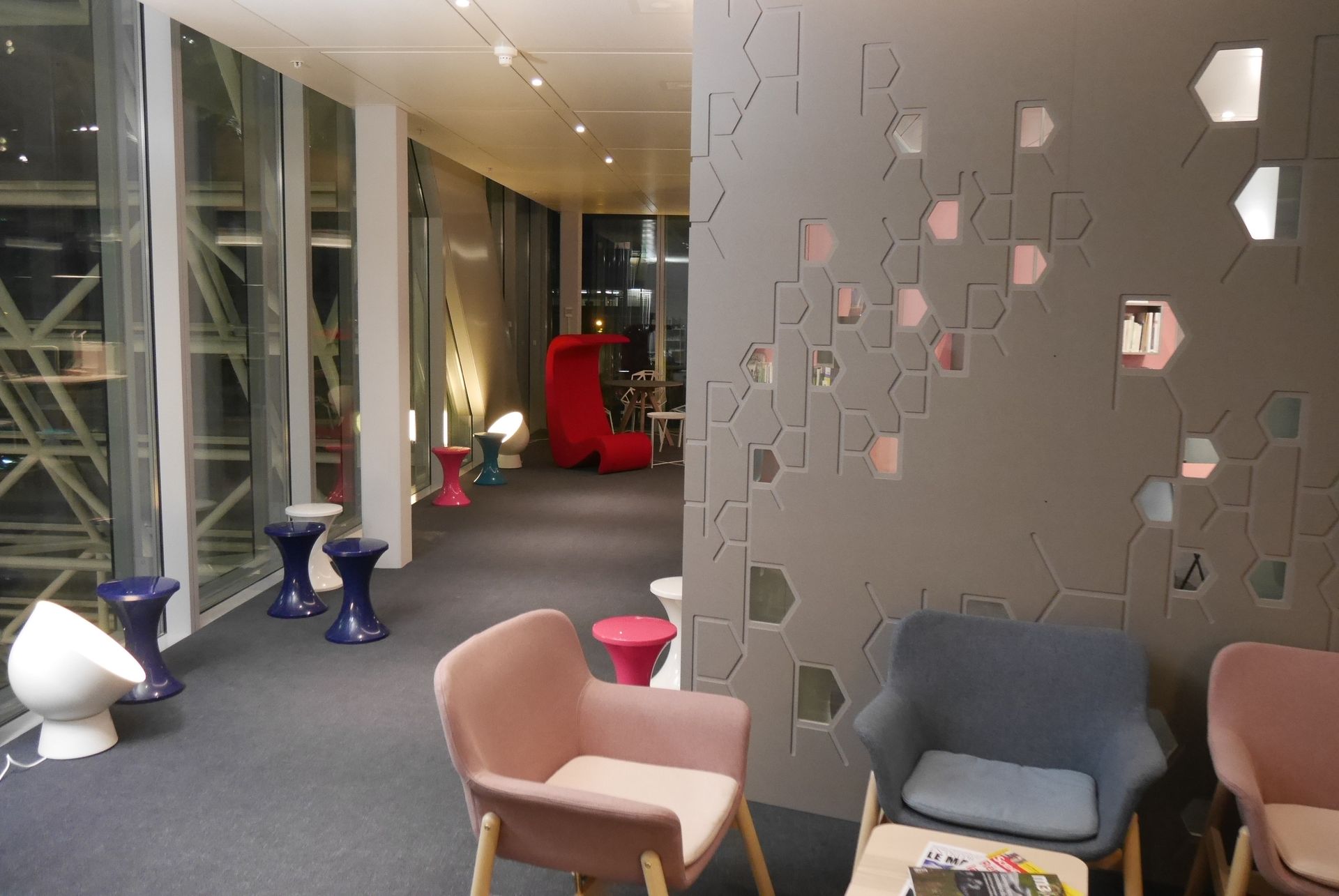 A room with chairs and stools and a puzzle wall