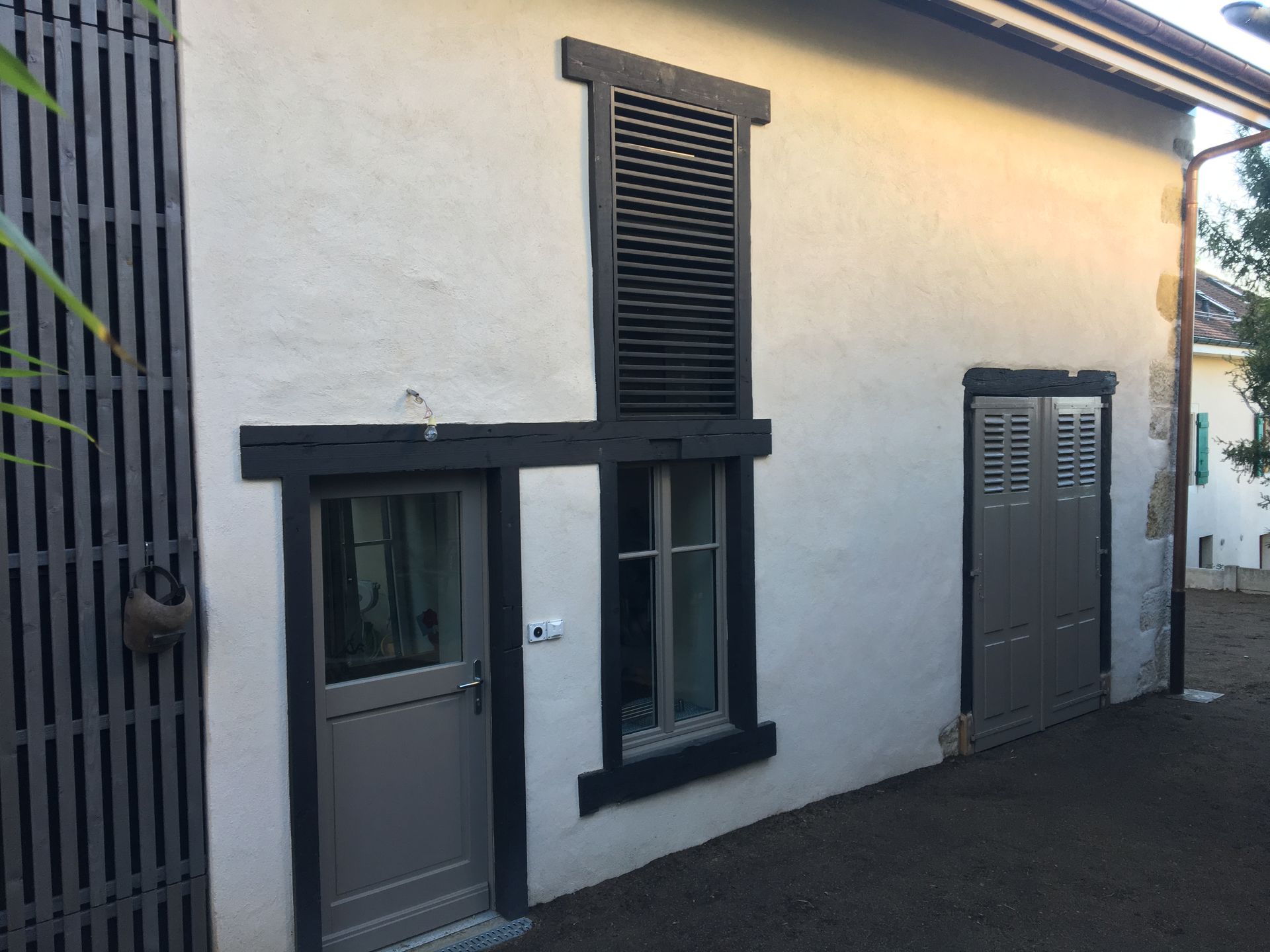 A white building with black shutters on the windows