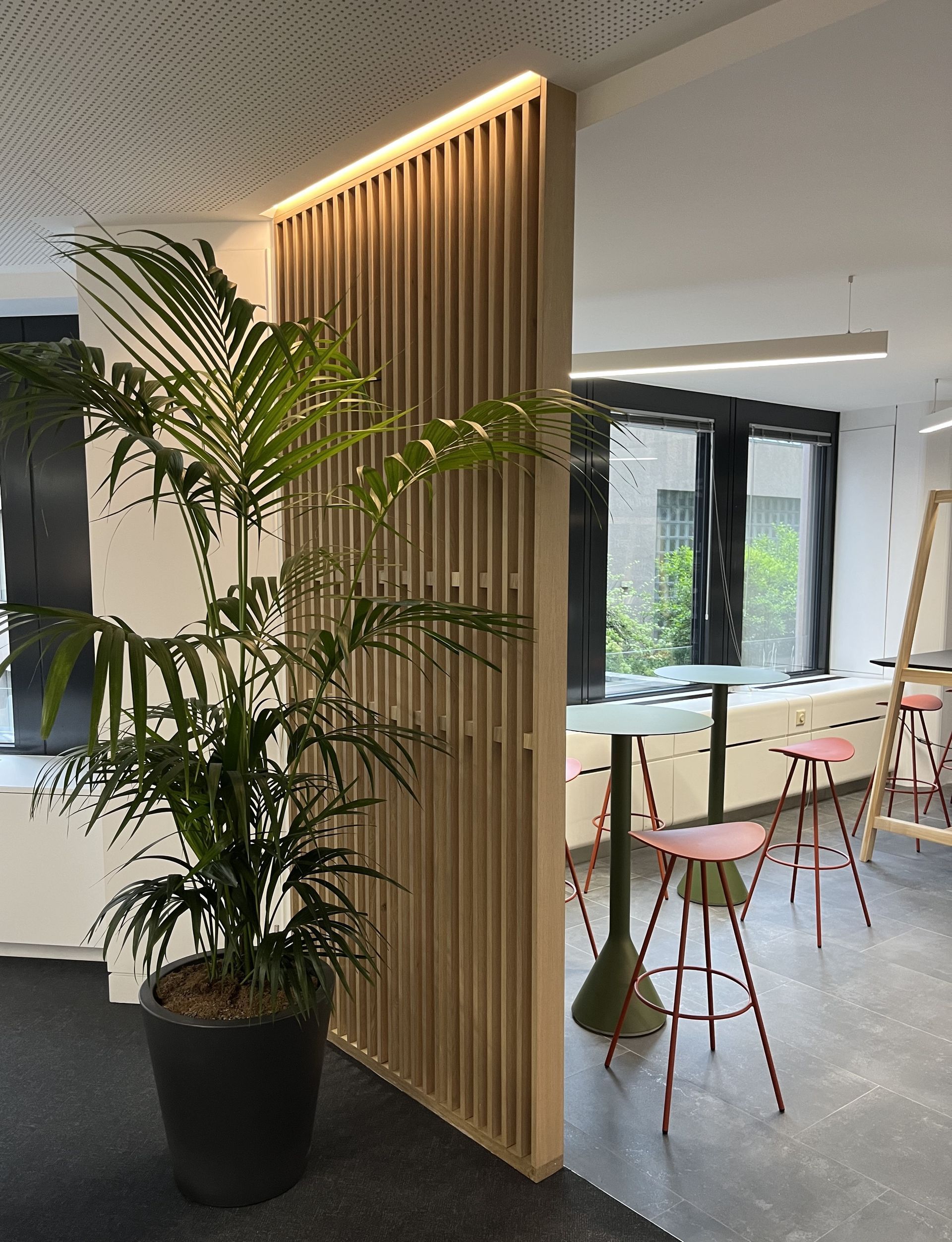 A potted plant is sitting in a room next to a wooden wall.