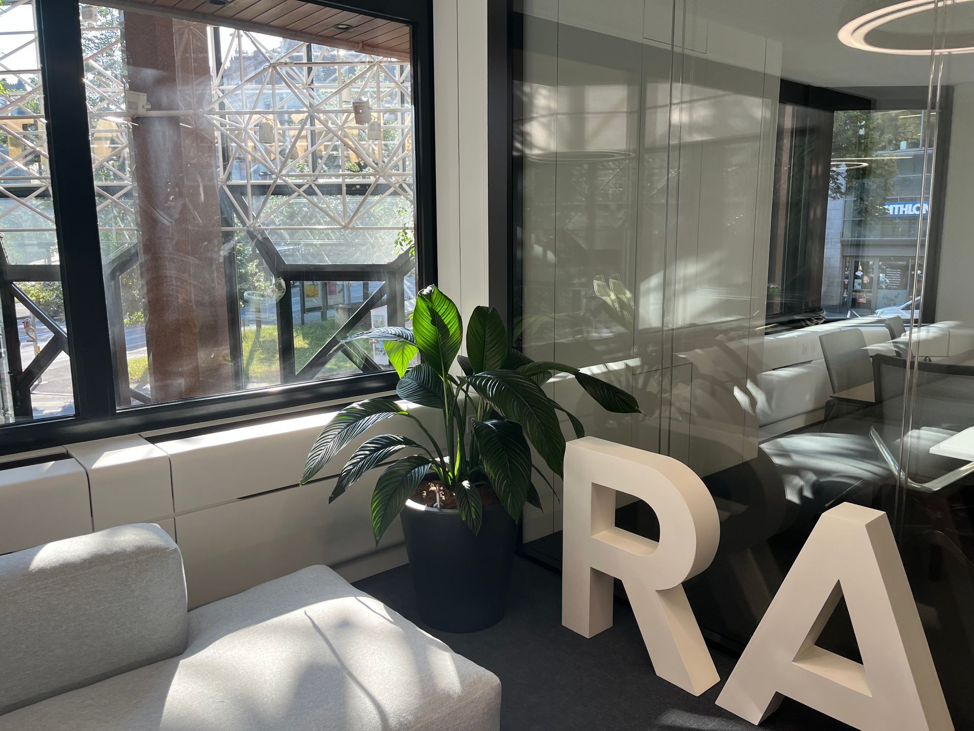 A room with a couch and a plant and a sign that says ra