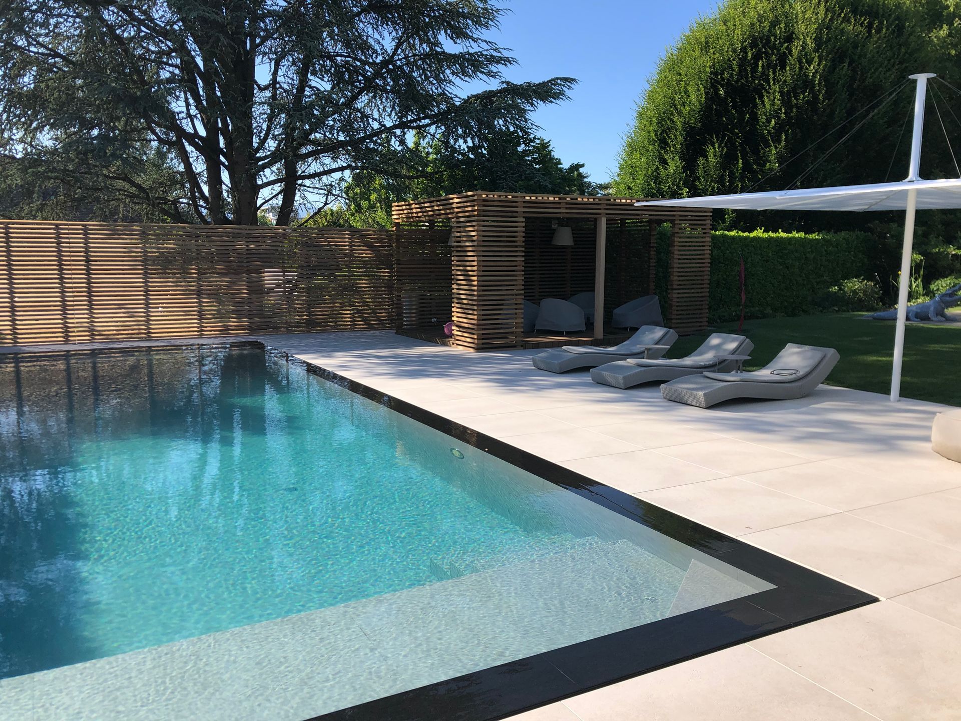 A large swimming pool surrounded by chairs and umbrellas