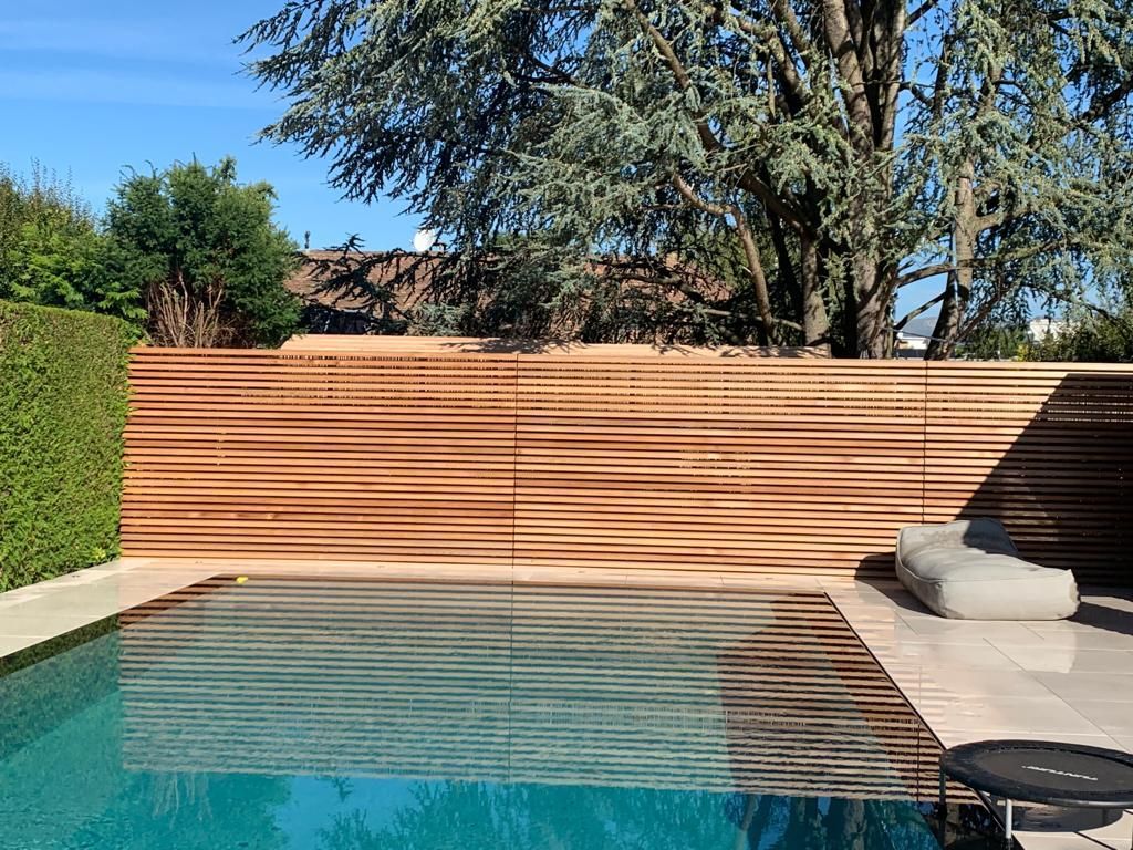 A large swimming pool with a wooden fence surrounding it.