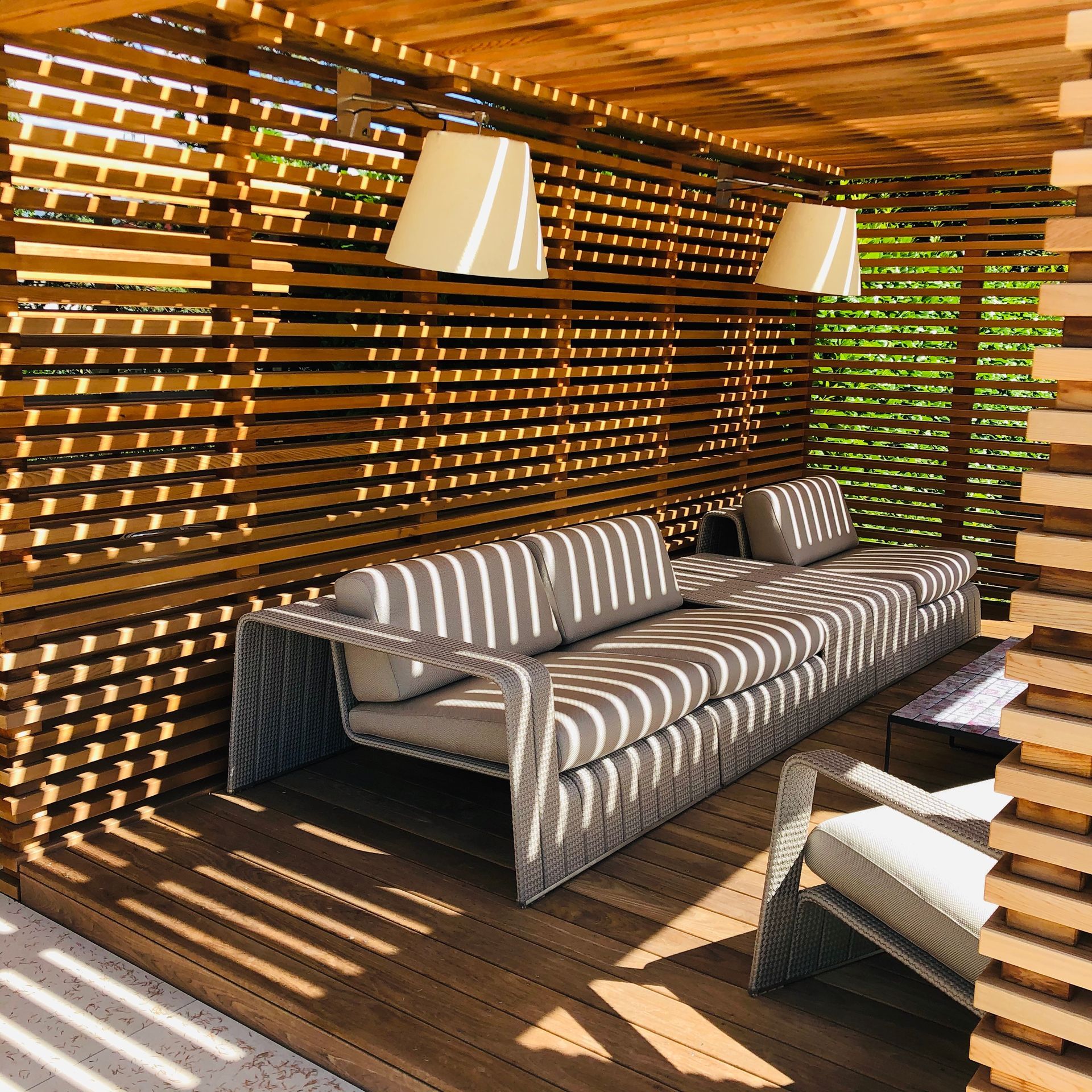 A patio with a couch and chairs under a wooden roof