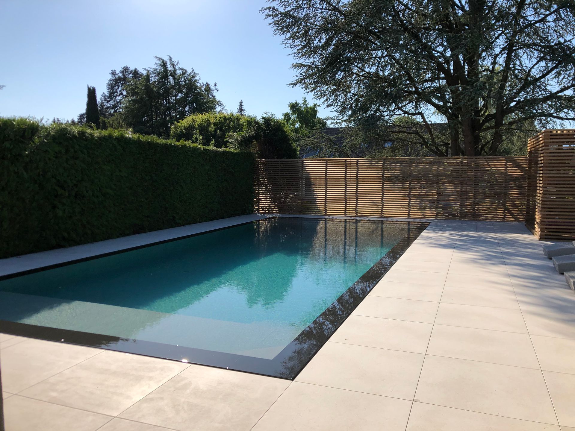 A large swimming pool with a wooden fence around it