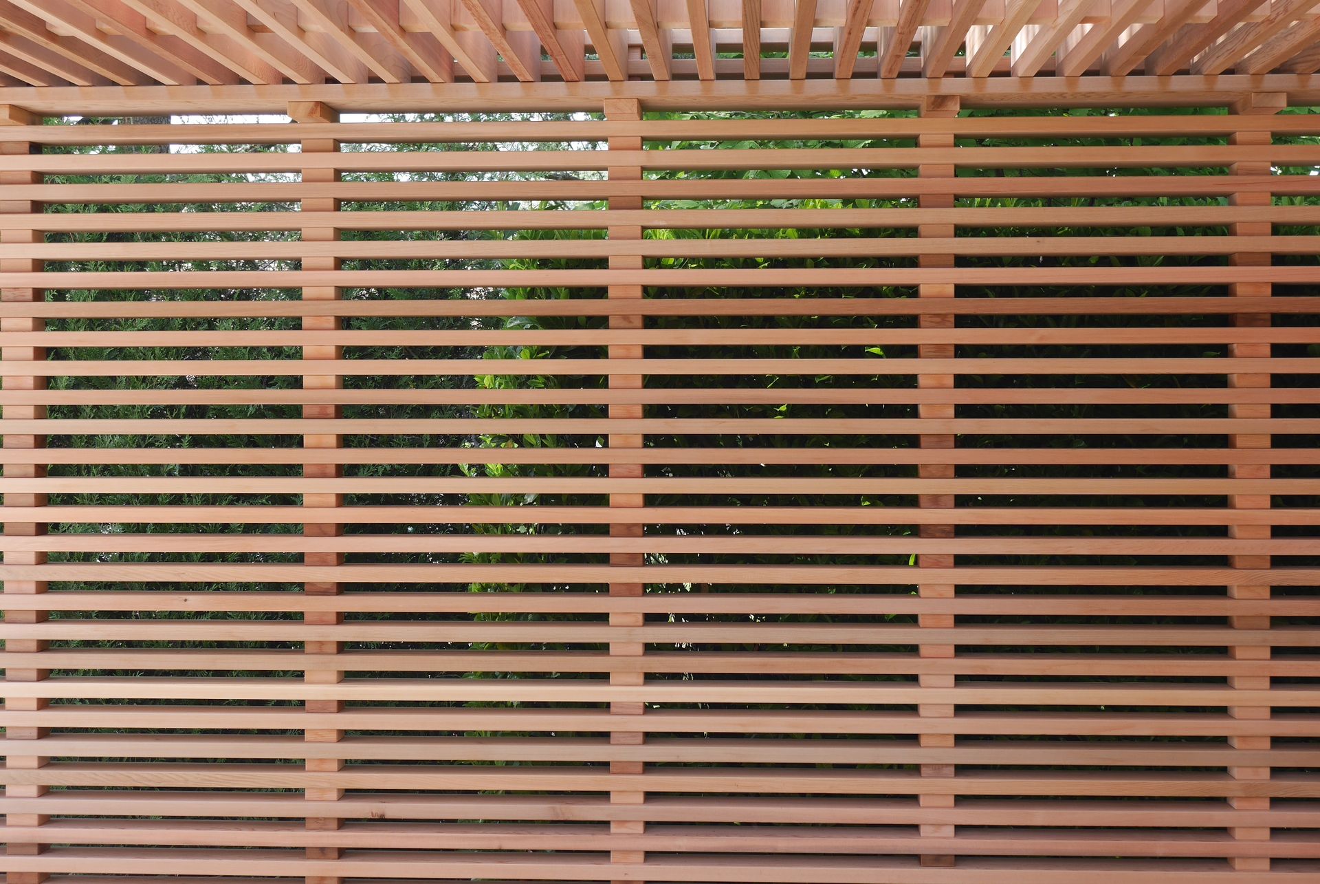 A close up of a wooden fence with trees in the background.