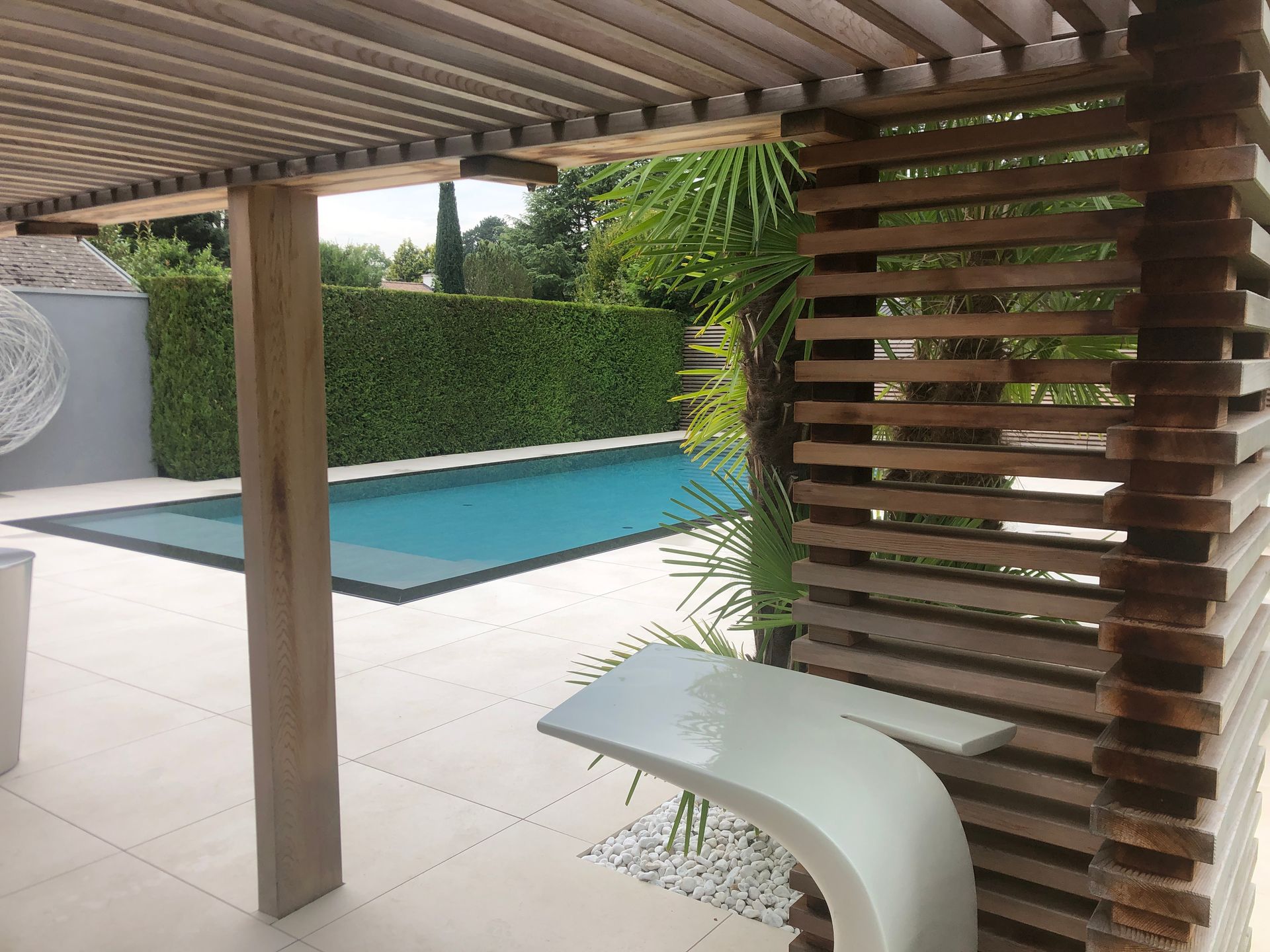 A large swimming pool is behind a wooden fence