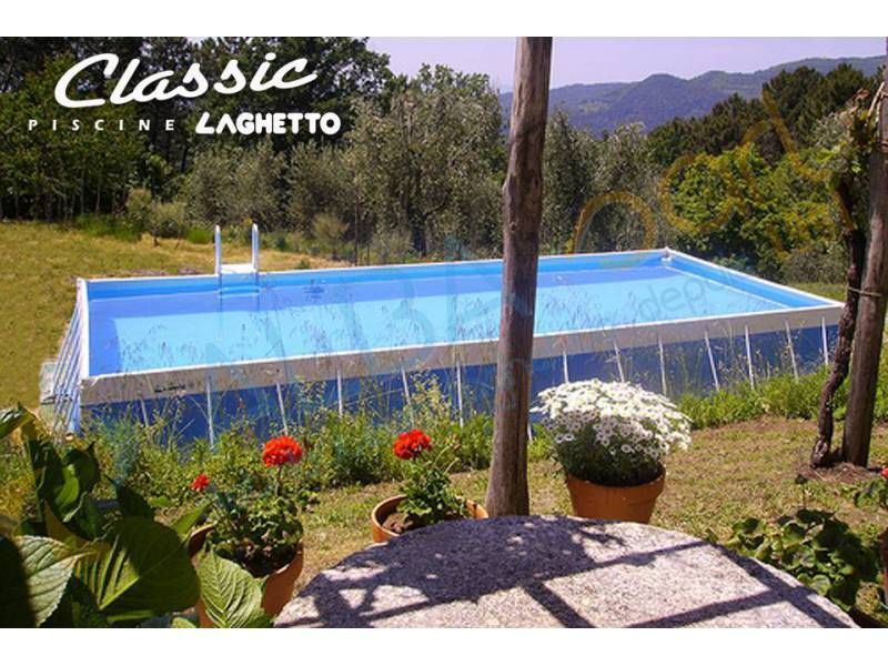 Piscine hors sol rectangulaire dans un jardin, avec des montagnes en arrière-plan et des fleurs rouges au premier plan.