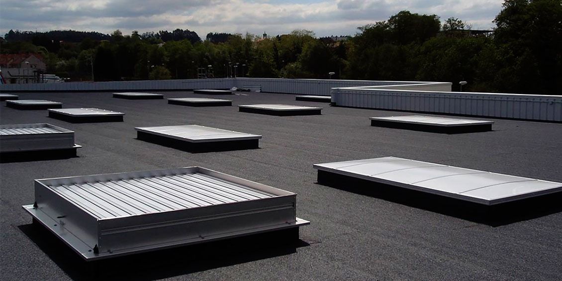 Azotea plana con múltiples unidades de ventilación plateadas bajo un cielo nublado.