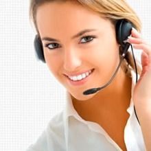 Agente de atención al cliente sonriente con auriculares y camisa blanca sobre un fondo claro