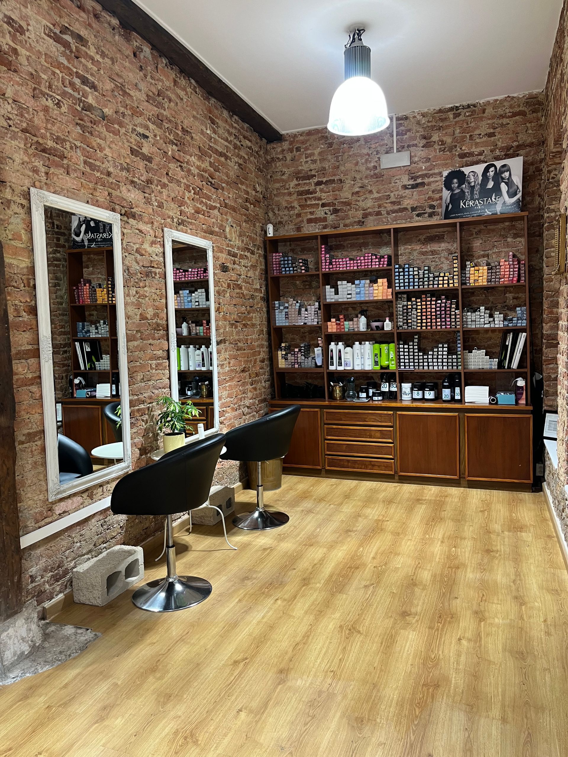 Una peluquería con pared de ladrillo y suelo de madera.
