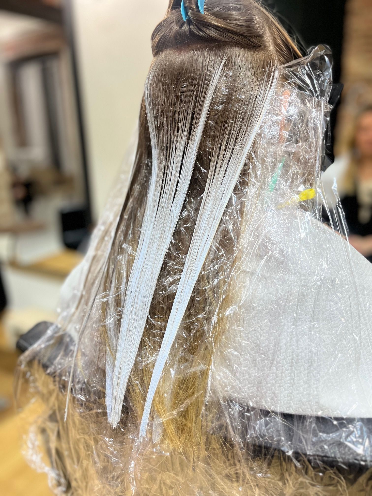 Una mujer se tiñe el pelo en un salón.