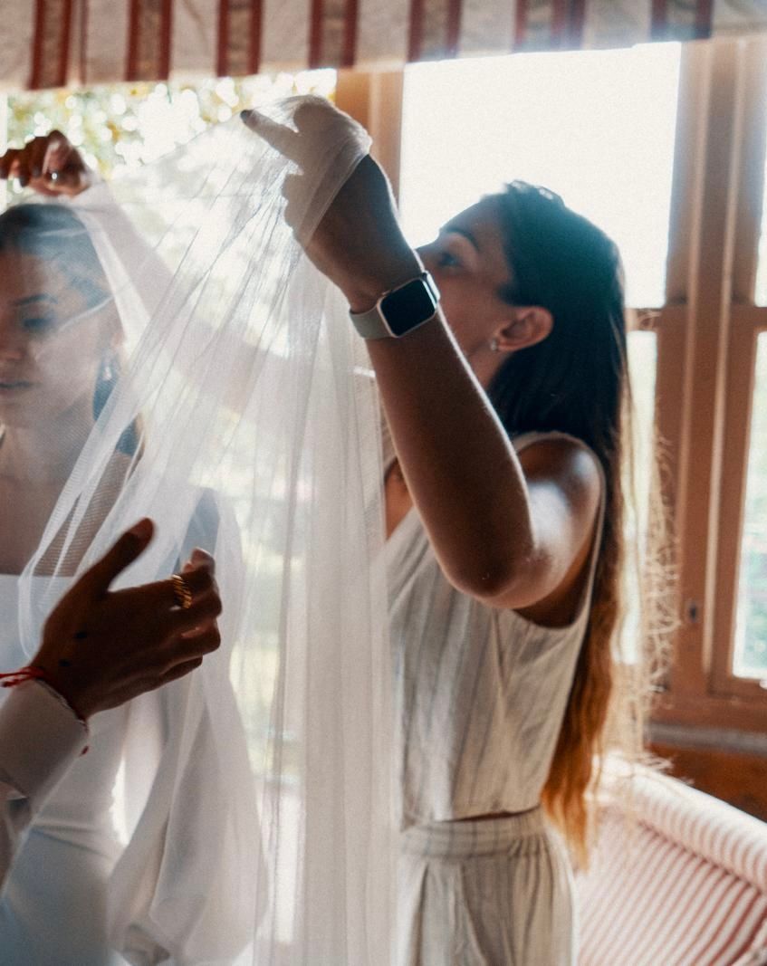 Una mujer con un vestido blanco se pone un velo.