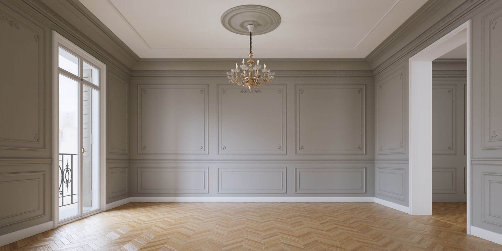 Pièce vide, lambrissée de gris, avec un lustre, un parquet et une porte donnant sur une autre pièce.