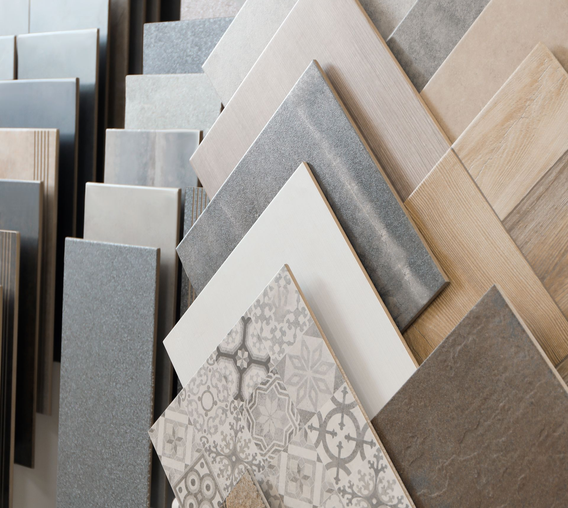 Présentation de divers échantillons de carreaux de céramique de couleurs et de motifs différents.