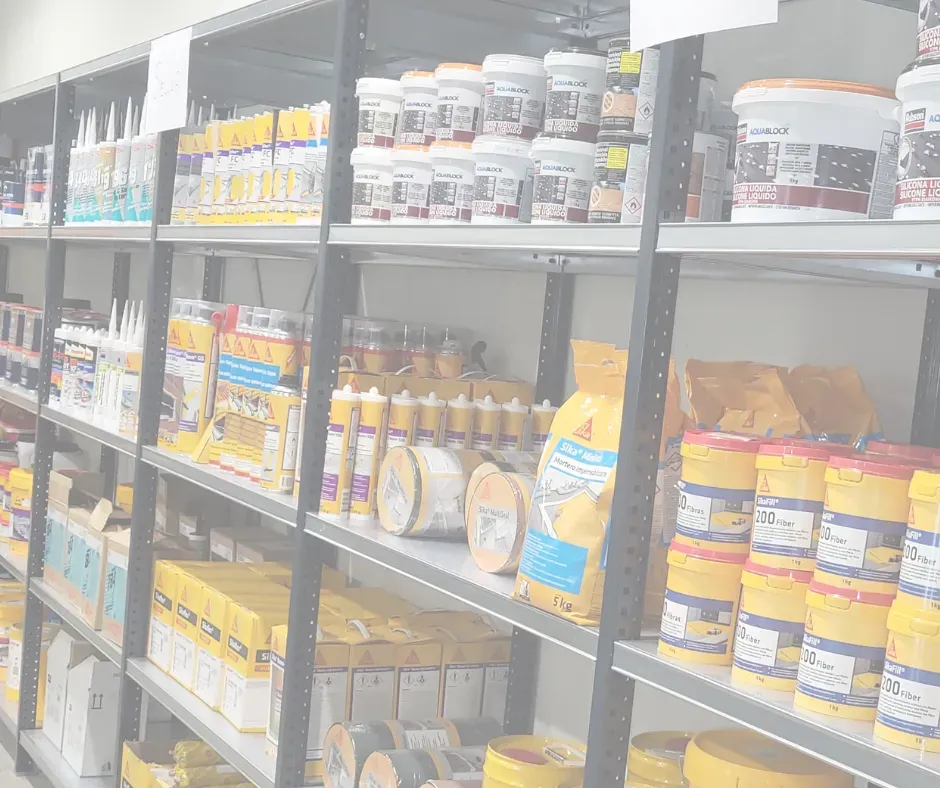 Estantes llenos de suministros de pintura y adhesivos de construcción en una tienda.