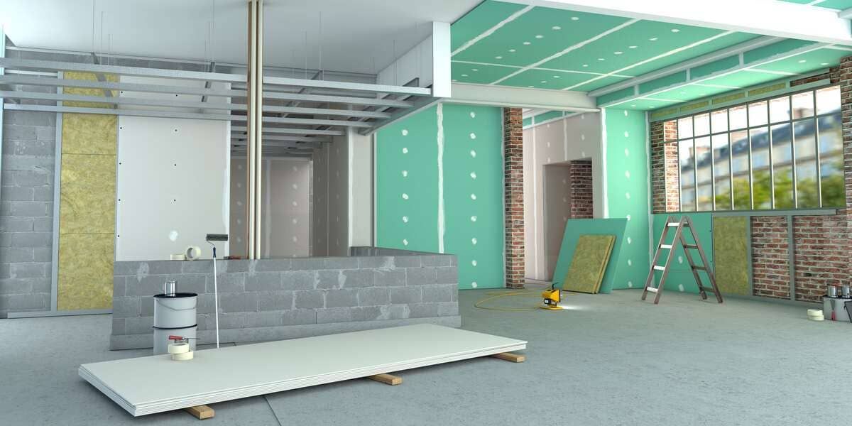 Una paleta mezcla cemento gris claro en un balde.