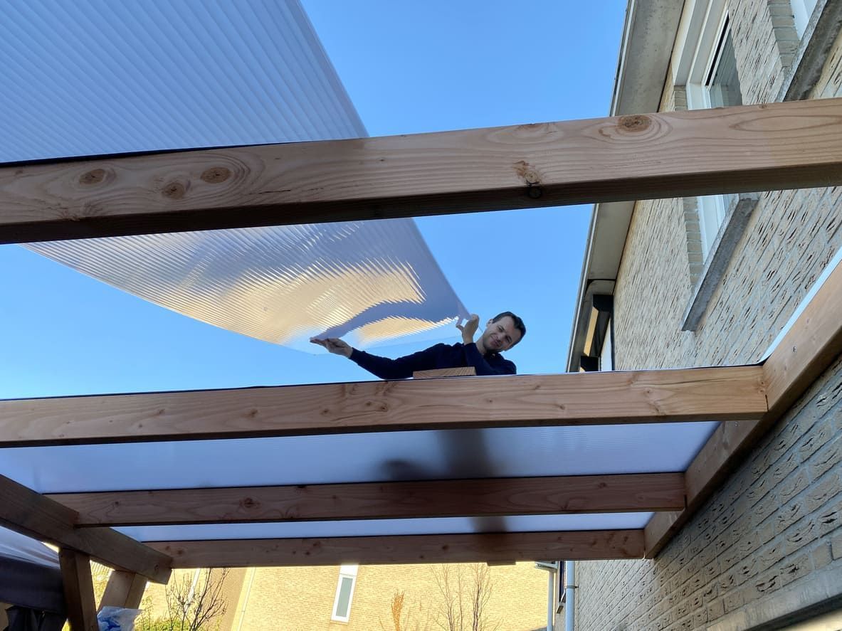 Persona calafateando una costura de esquina con una pistola de calafateo roja y blanca.