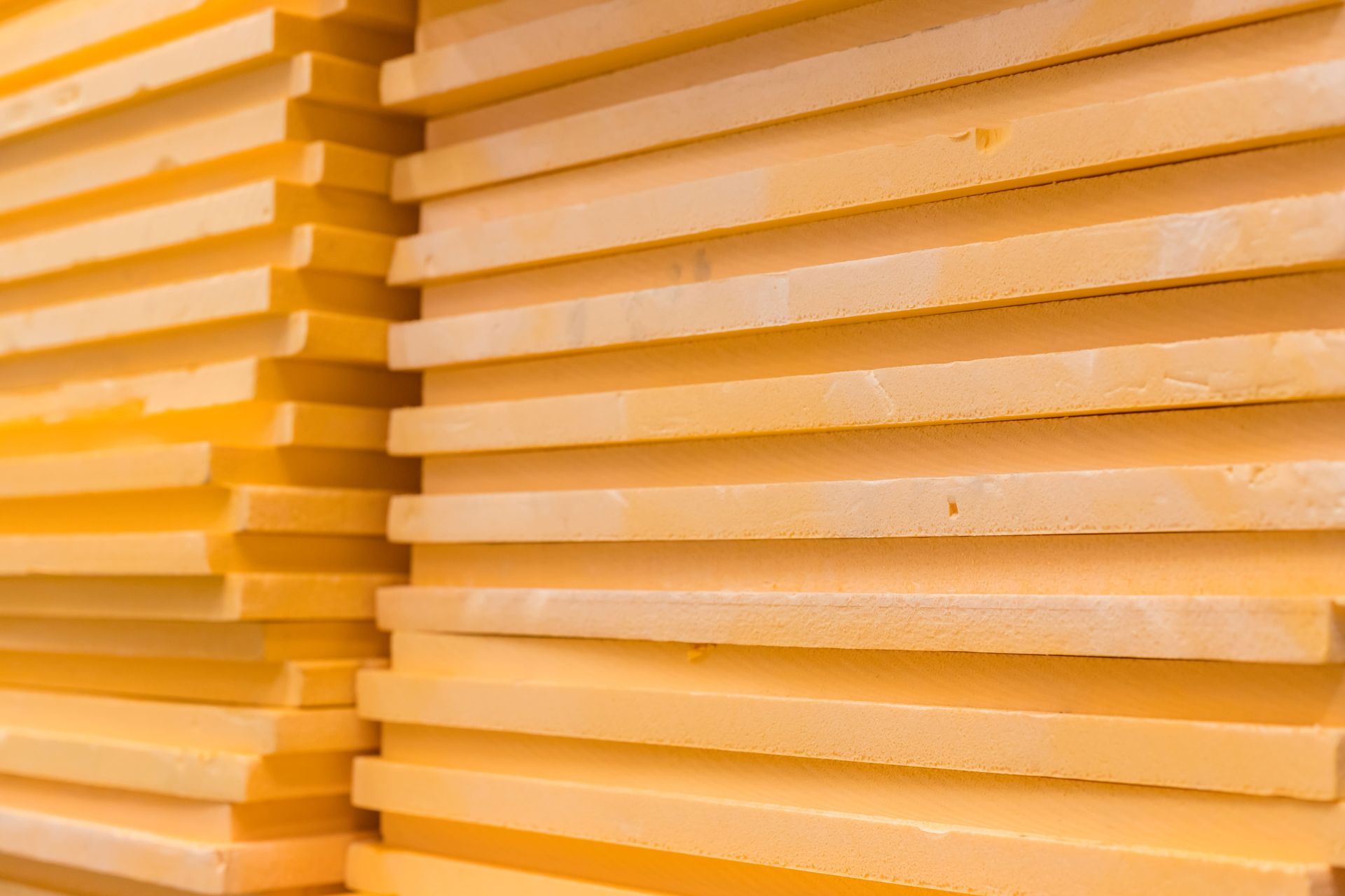 Pila de paneles aislantes de espuma de color amarillo brillante.