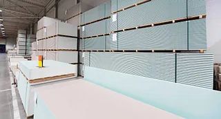 Pilas de láminas de yeso en un gran almacén.