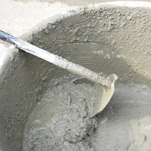 Mezcla de cemento revuelta con una paleta en un balde.