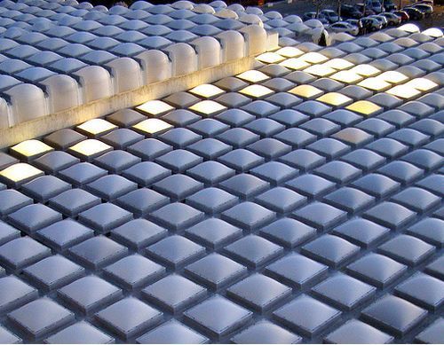 Filas de estructuras blancas, cuadradas y abovedadas, algunas de ellas iluminadas.