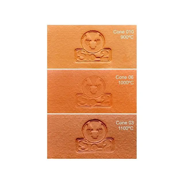 Tres baldosas de prueba de cerámica de color terracota que muestran variaciones de color a diferentes temperaturas de cocción.