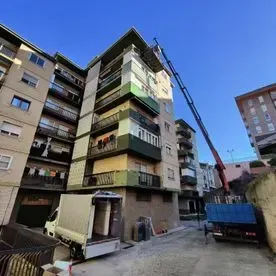 Un gran edificio con un camión estacionado delante de él.