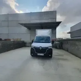 Una camioneta blanca está estacionada frente a un edificio.
