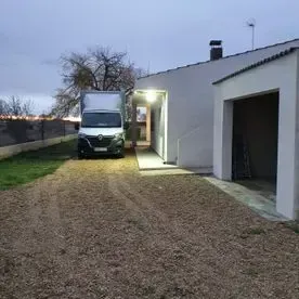 Una camioneta blanca está estacionada frente a una casa.