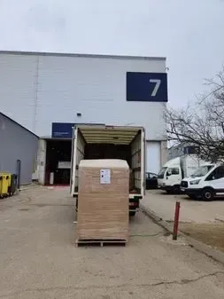 Un camión está estacionado frente a un edificio con el número 7 en él.