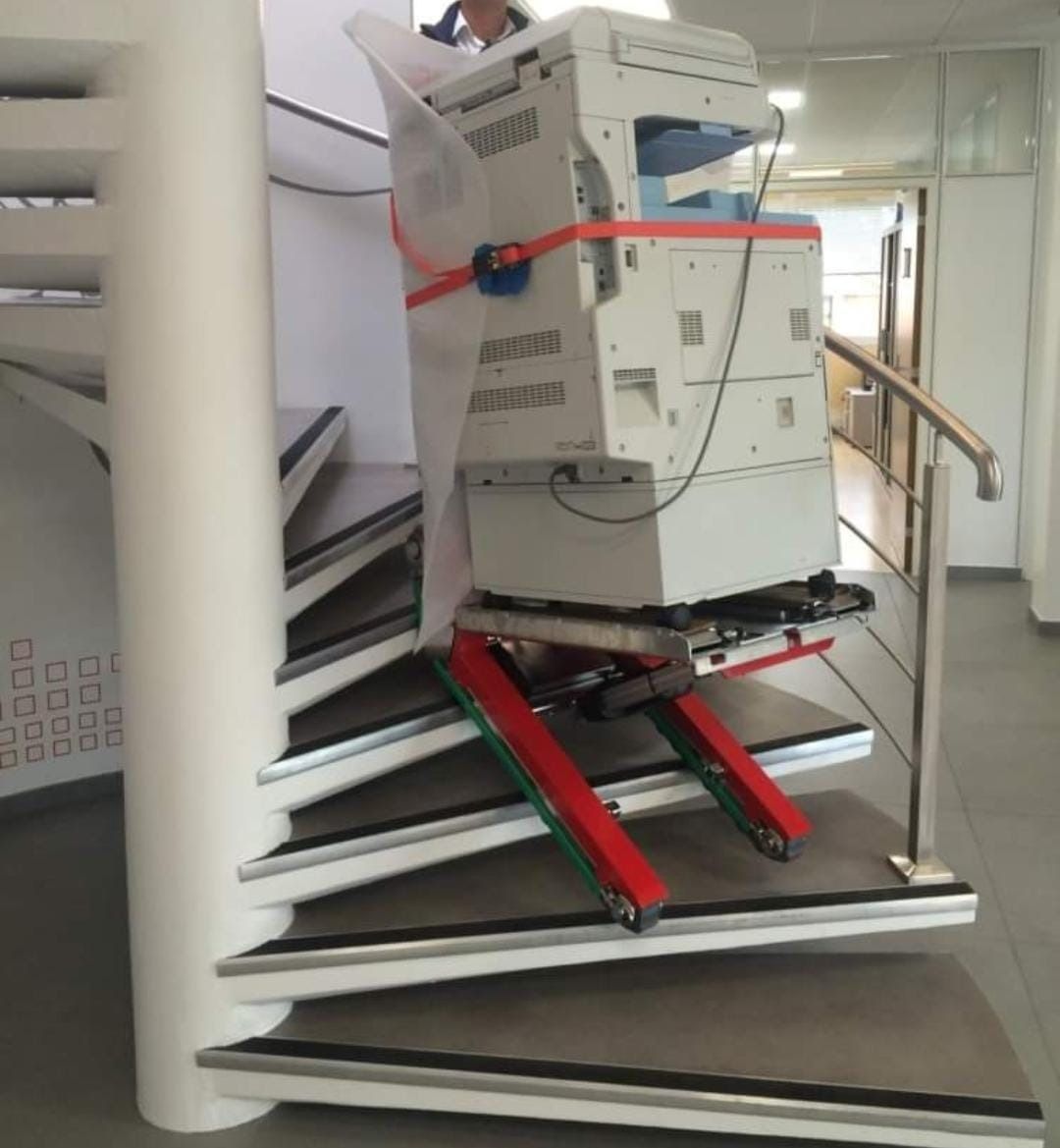 Una impresora está subiendo por unas escaleras de caracol.