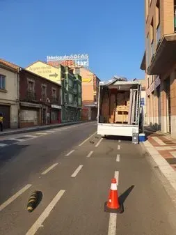 Un camión está estacionado al costado de la carretera al lado de un cono de tráfico.