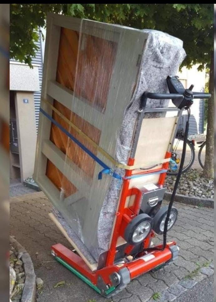 Se está moviendo un piano en un carro con ruedas.