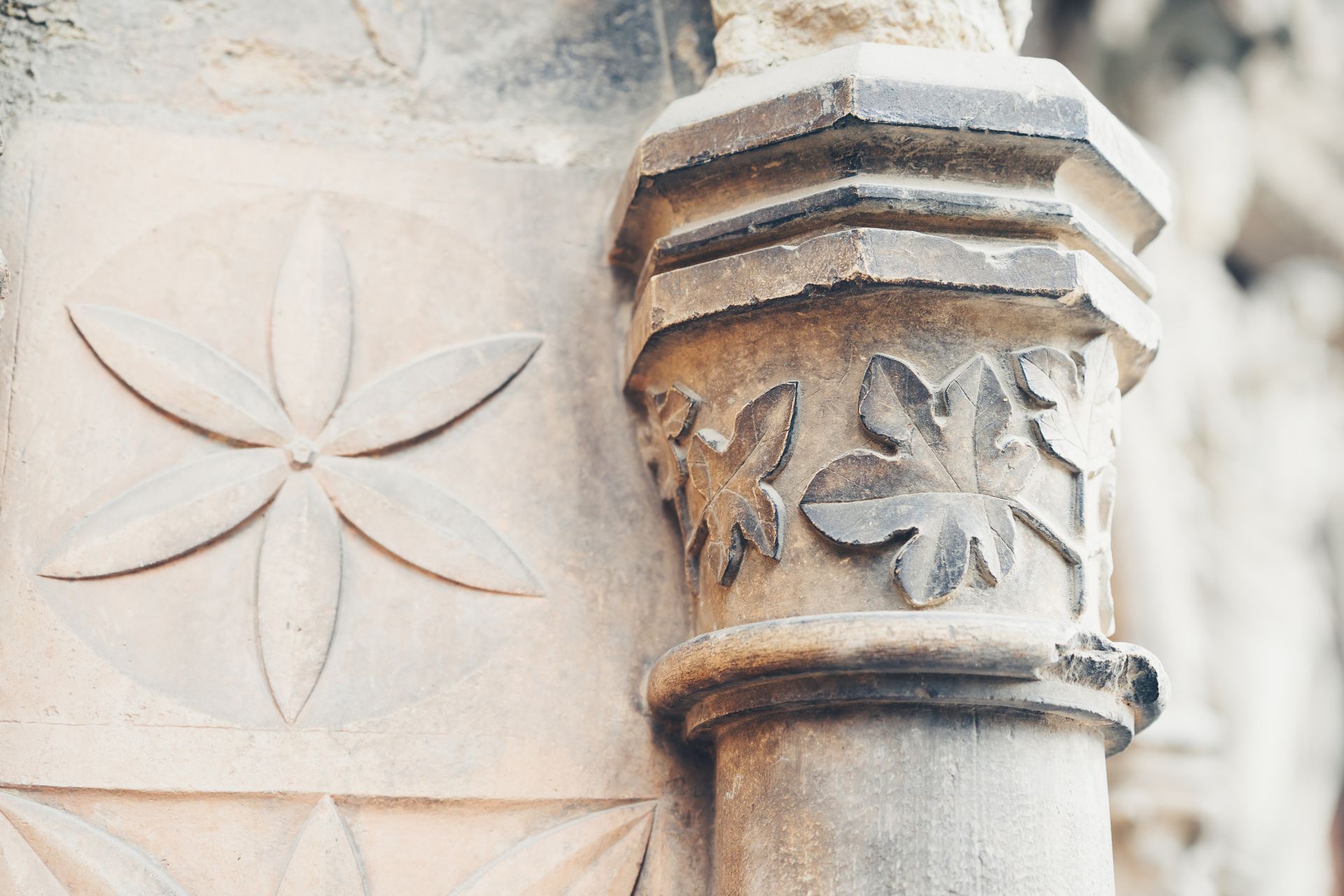 Un primer plano de una columna de piedra con una flor tallada en ella.