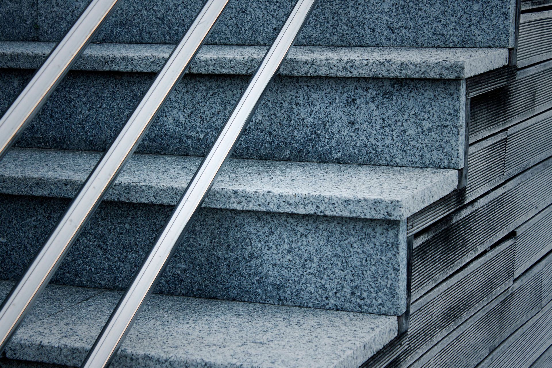 Un primer plano de un conjunto de escaleras con barandilla de metal.