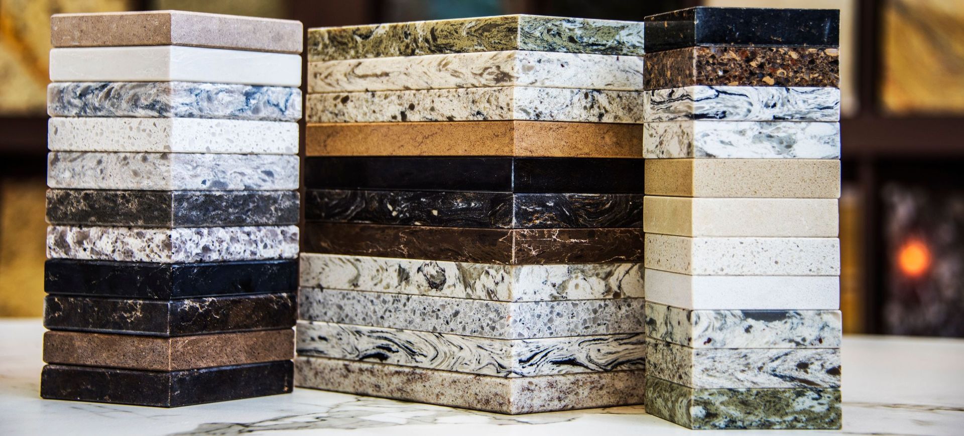 Tres pilas de losas de granito de diferentes colores están colocadas sobre una mesa.