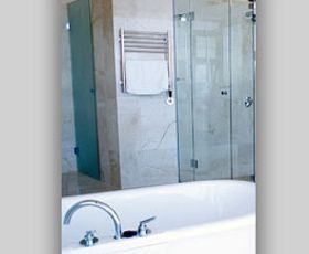 Un baño con bañera, ducha y espejo.